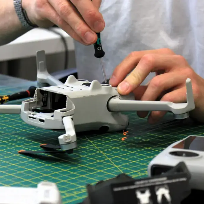 Serviser koji pomoću odvijača otvara DJI dron